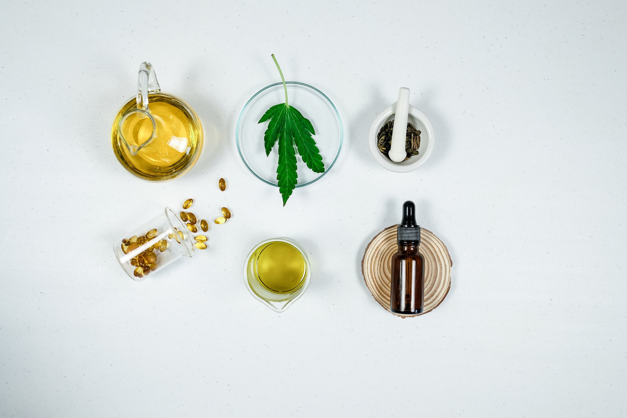 cbd, thc oil, capsules, and marijuana leaf on a table