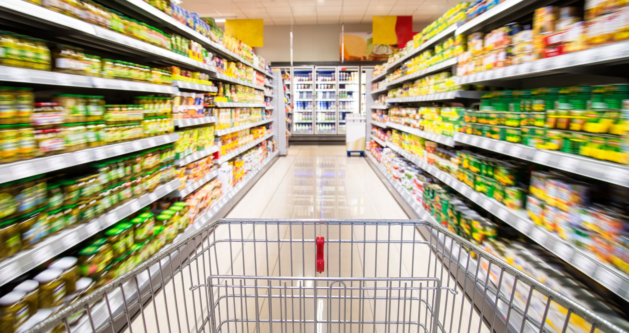 Consumer staples in jars on supermarket shelves.