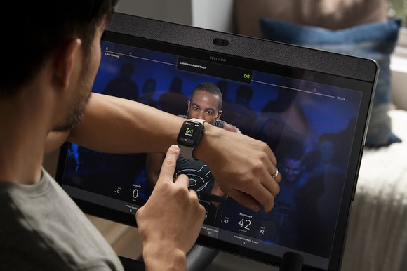 A Peloton rider checks his Apple Watch