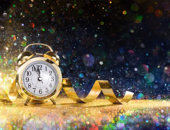A golden clock surrounded by confetti.