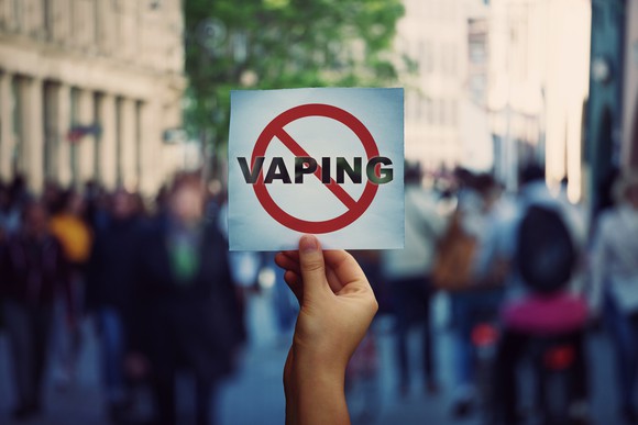Human hand holding a protest banner with stop vaping message