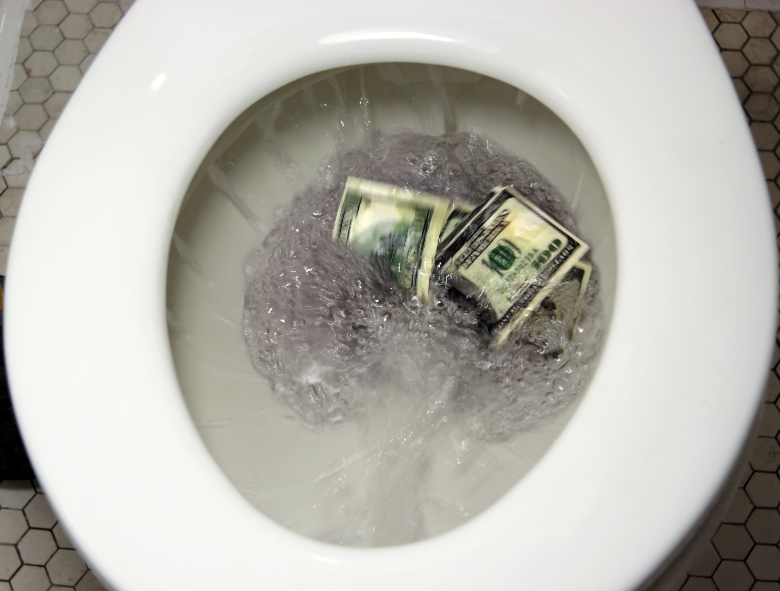 Flushing $100 bills down the toilet.
