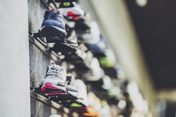 Multicolored sports shoes or running shoes on a store wall display.