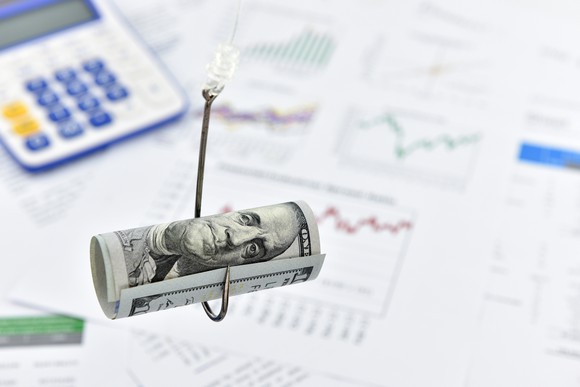 $100 bill rolled up on a hook. 