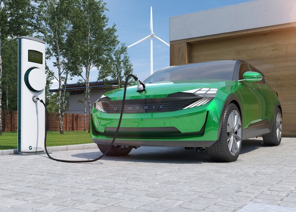 An electric vehicle gets a charge in a driveway.