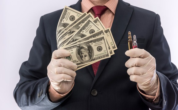 Man in suit wearing gloves holding cash and vials 