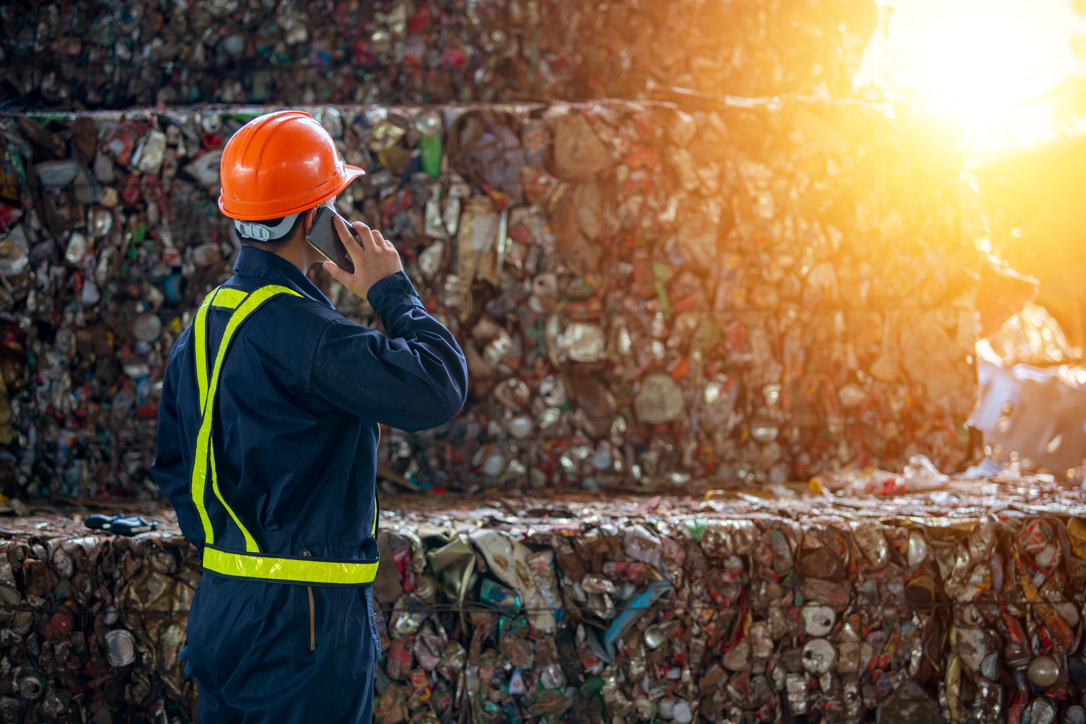 A worker manages the process of packing waste for recycling. 