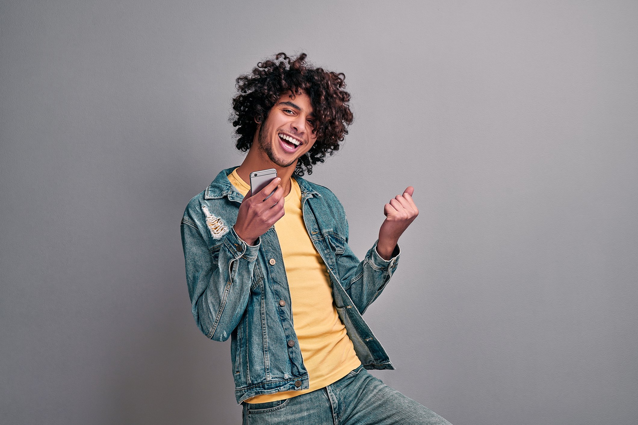 Smiling man dancing with smartphone