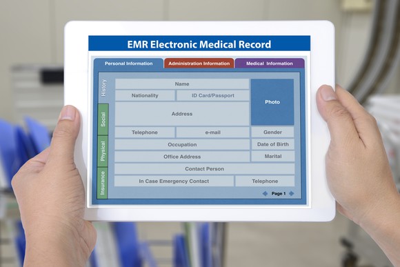 an electronic medical record on a tablet held by two hands