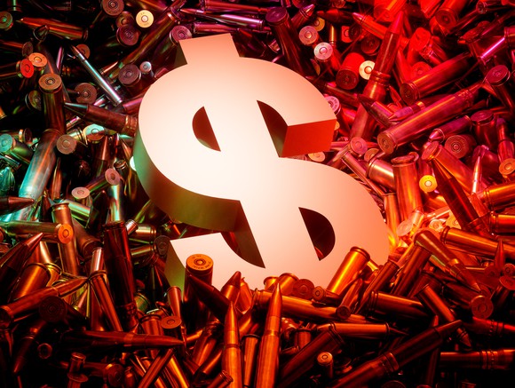 Dollar sign on pile of ammunition casings