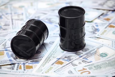 Two oil barrels on top of U.S. currency.