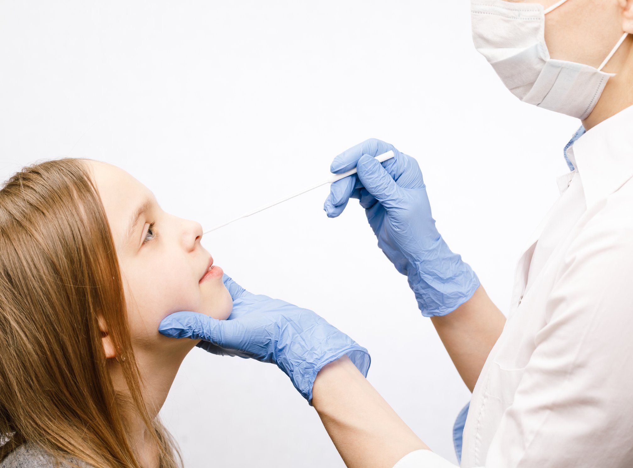 A clinician takes a nasal swab from a child.