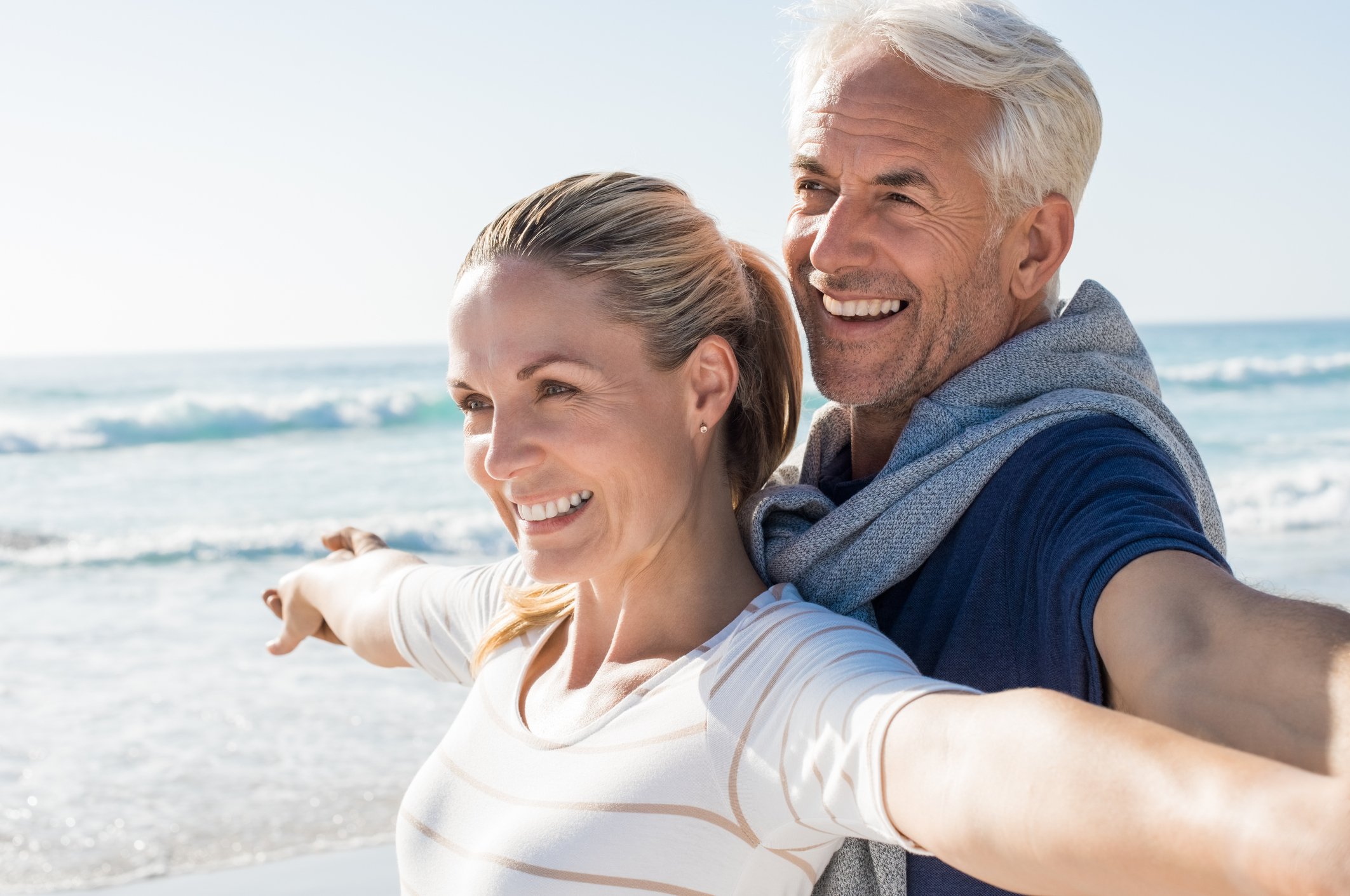 An older couple enjoying themselves on a beach. 