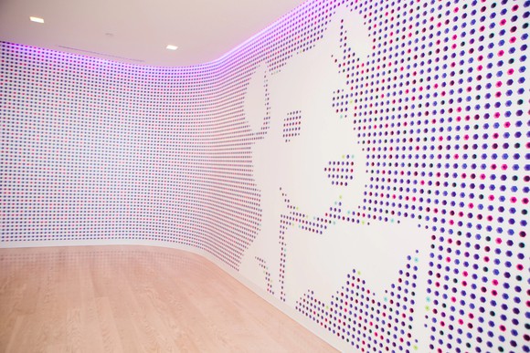 Datadog logo of a dog holding a rectangular graph, put on a lobby wall.