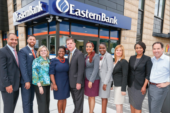 Eastern Bank team members stand together in front of a branch office. 