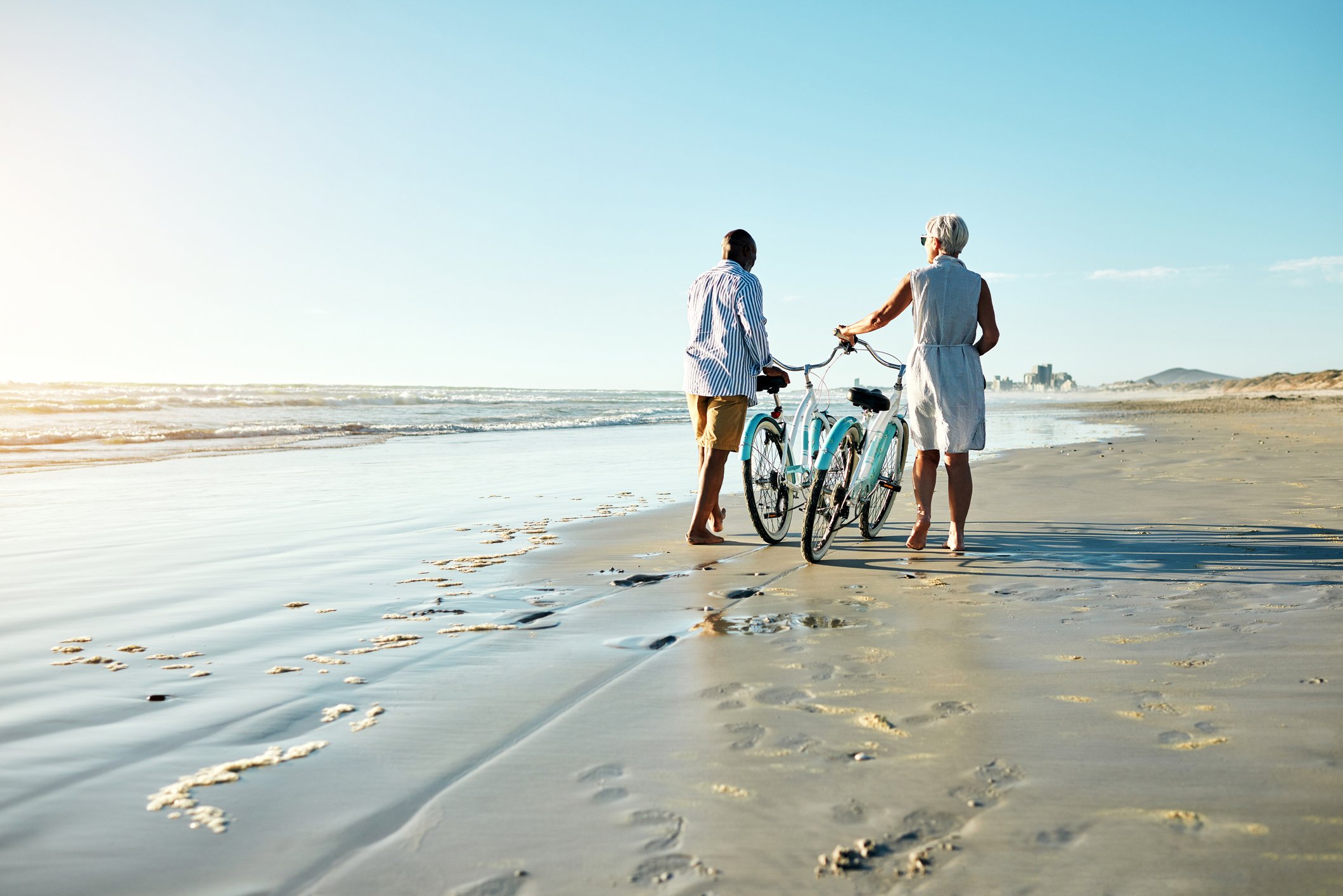 retired couple on beach with bikes