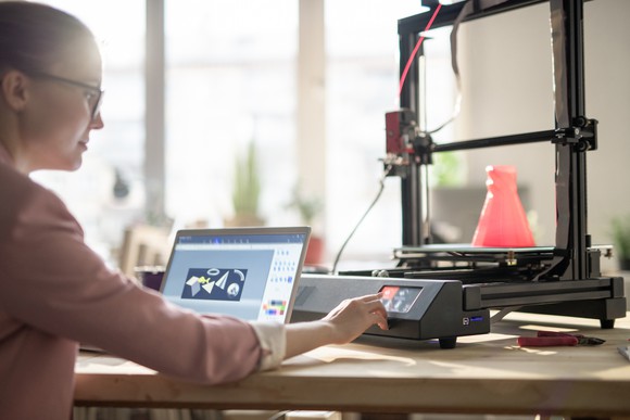 A woman uses a 3D printer.