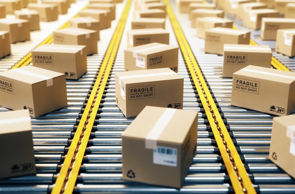 Boxes moving on a series of conveyor belts.