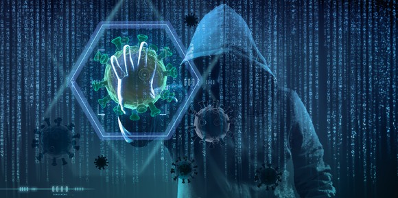 A hooded person holds out his hand illuminating a hologram sextagonal key. 