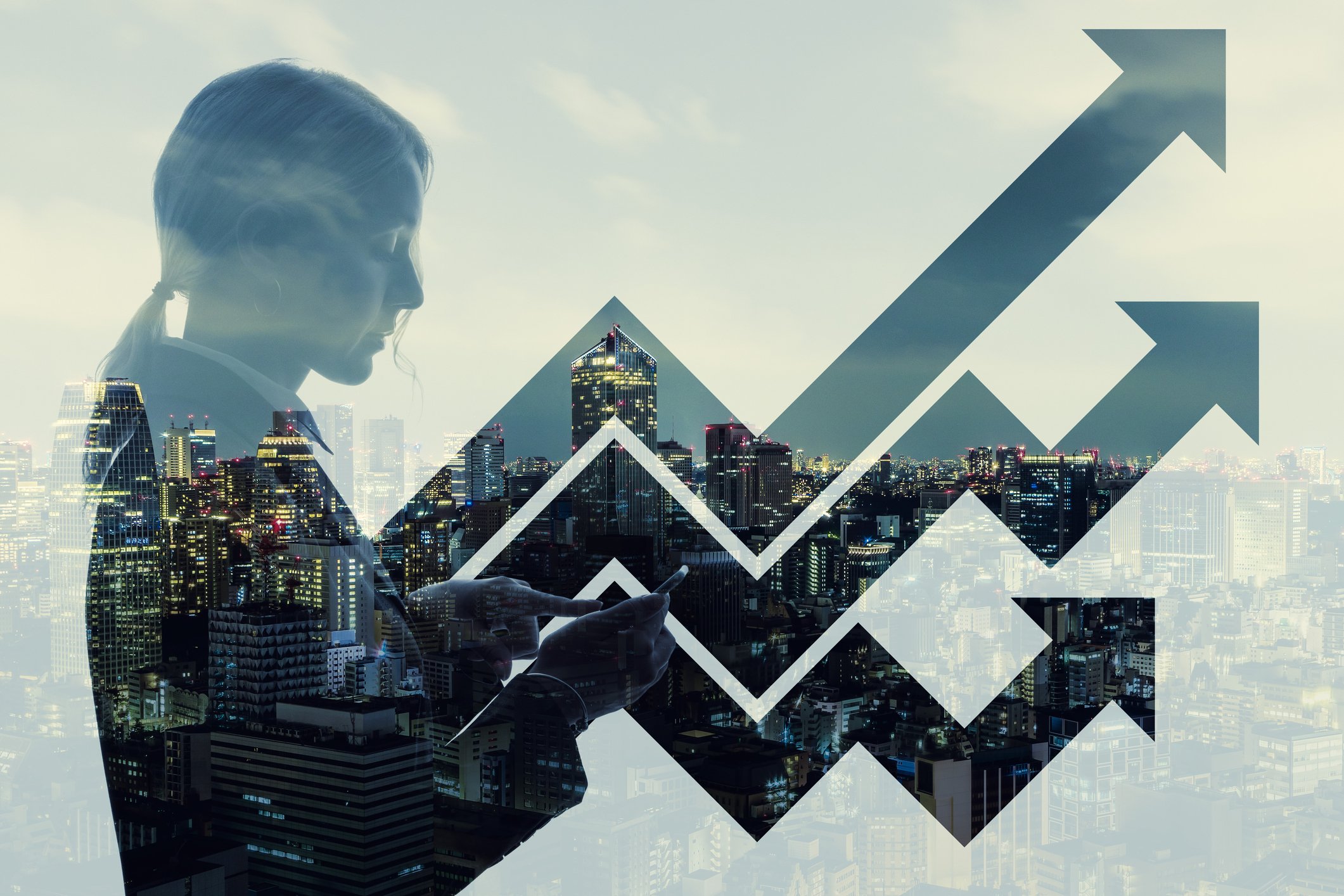 Side view of a young woman looking at a smartphone with three lines trending upward and a city landscape in the background. 