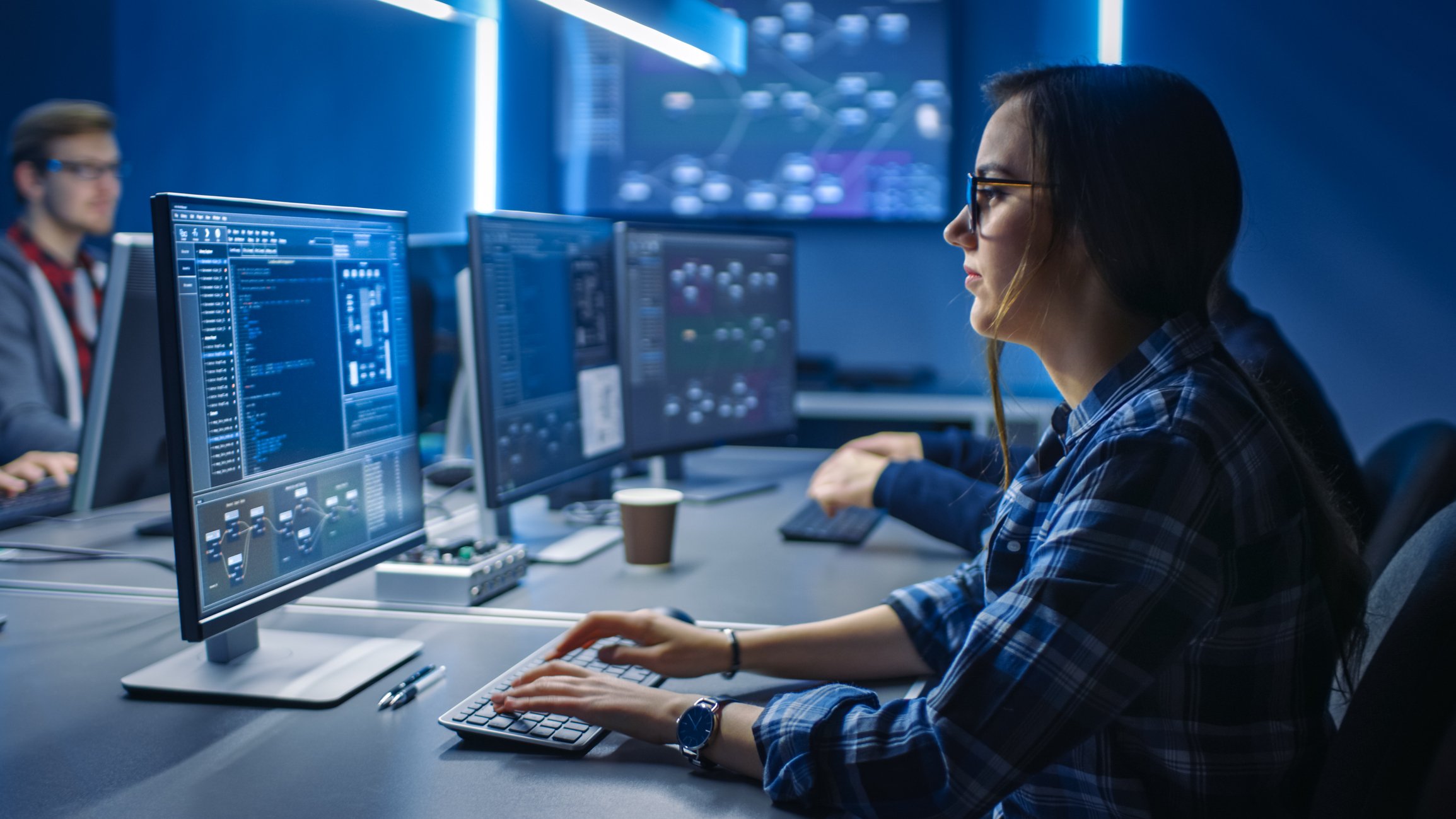 A female security worker in am office on her computer. 