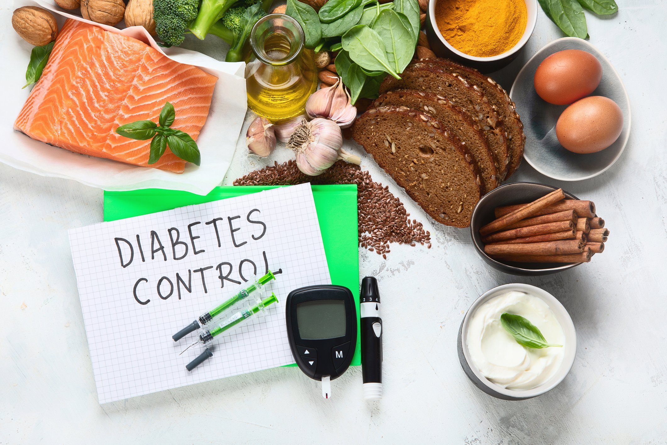 A table with fresh, healthy foods, a glucose monitor, and card that reads "Diabetes Control."