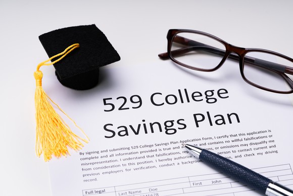 529 plan document with glasses, pen, and mortarboard