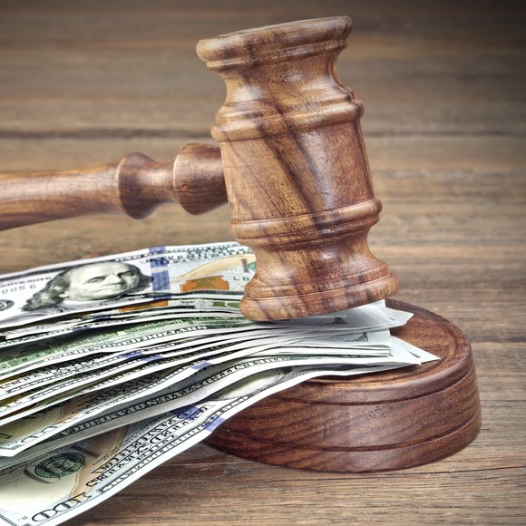 Judge's gavel on top of a money stack.