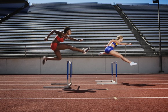 Two runners in a close hurdling race