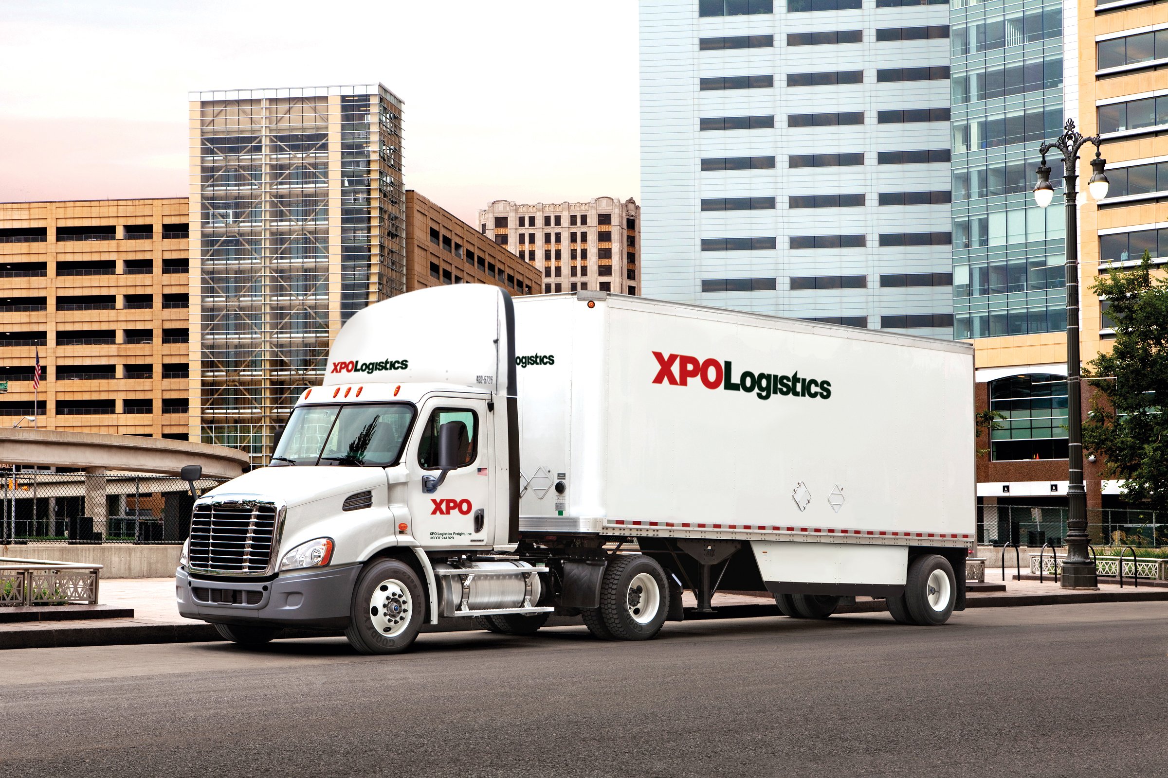 An XPO truck driving on a city street.