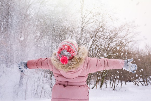 Woman enjoying a fresh snowfall.