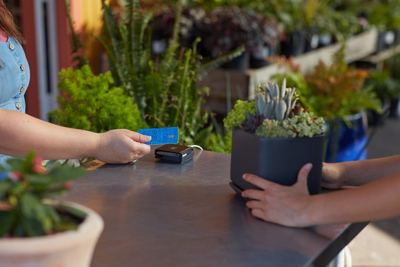 Customer using a Venmo Credit Card to buy a plant.