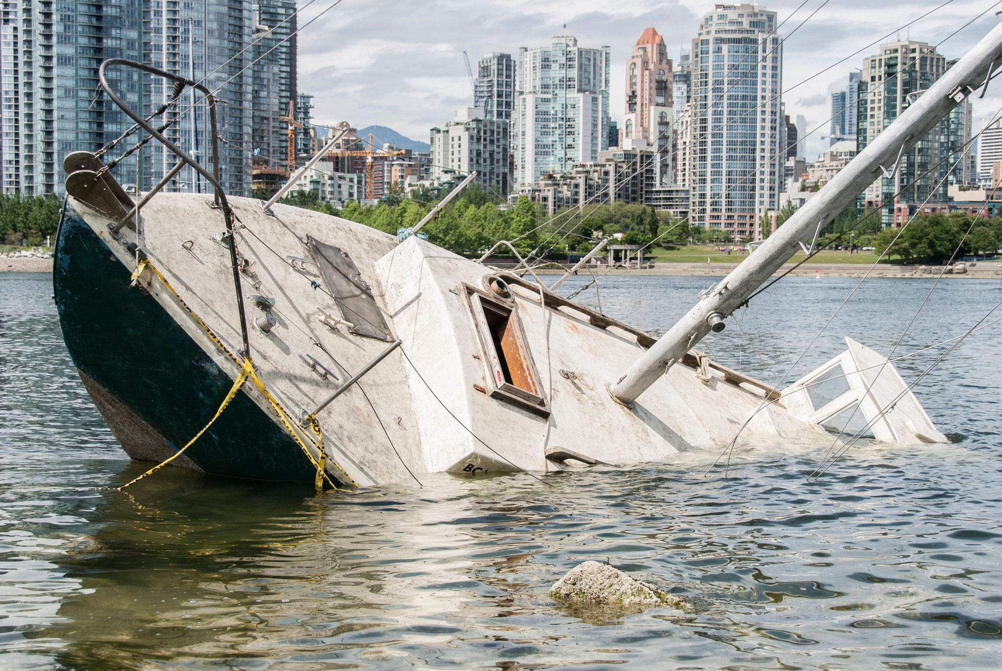 Boat sinking in front of a waterfront city