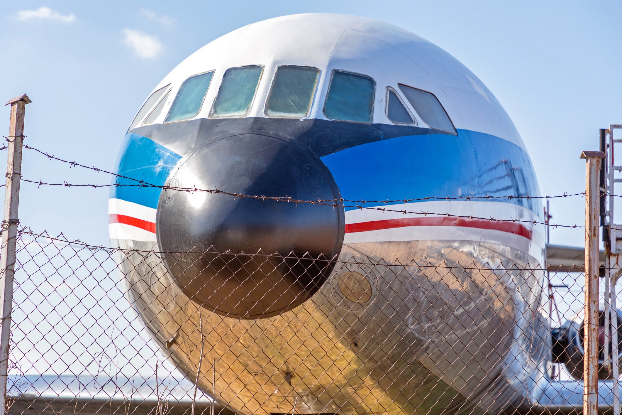 Abandoned airplane parked at barbed wire fence