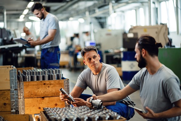Workers with boxes at manufacturing plant