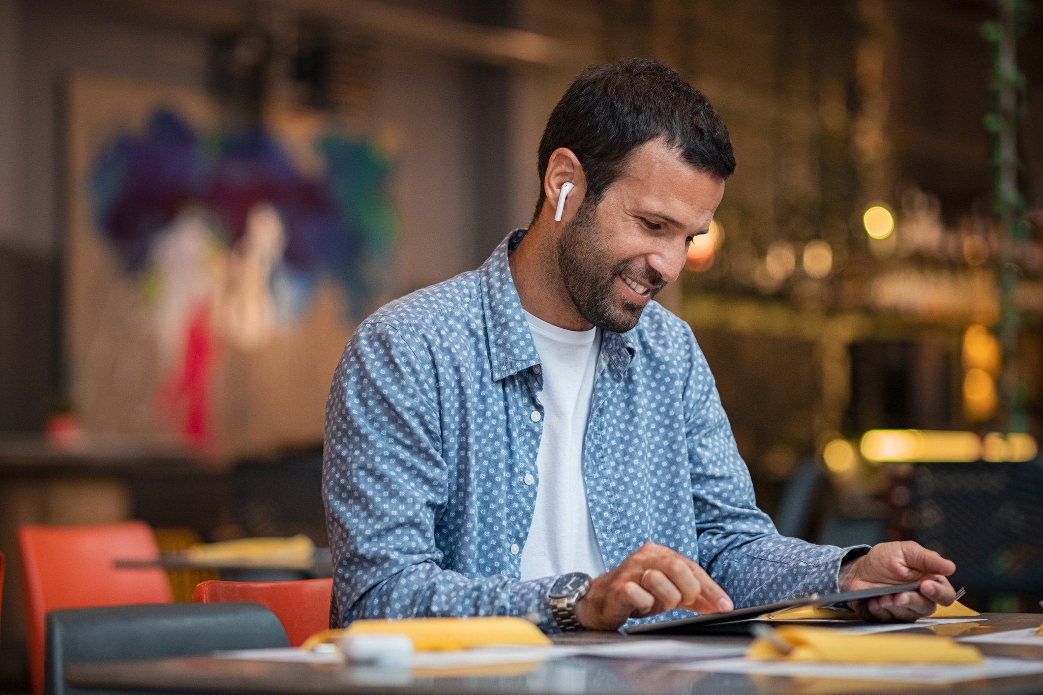 A man wearing wireless in-ear headphones.