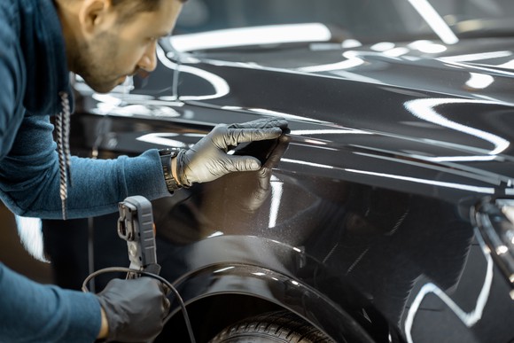 A man inspecting a vehicle.