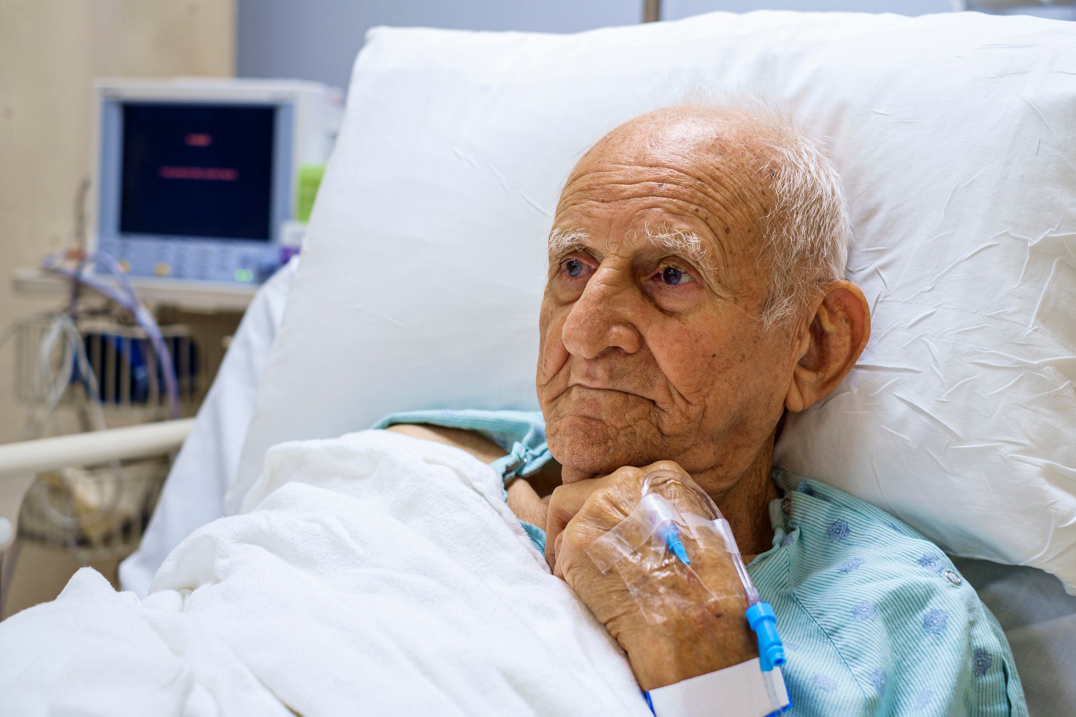 Older person in hospital bed.
