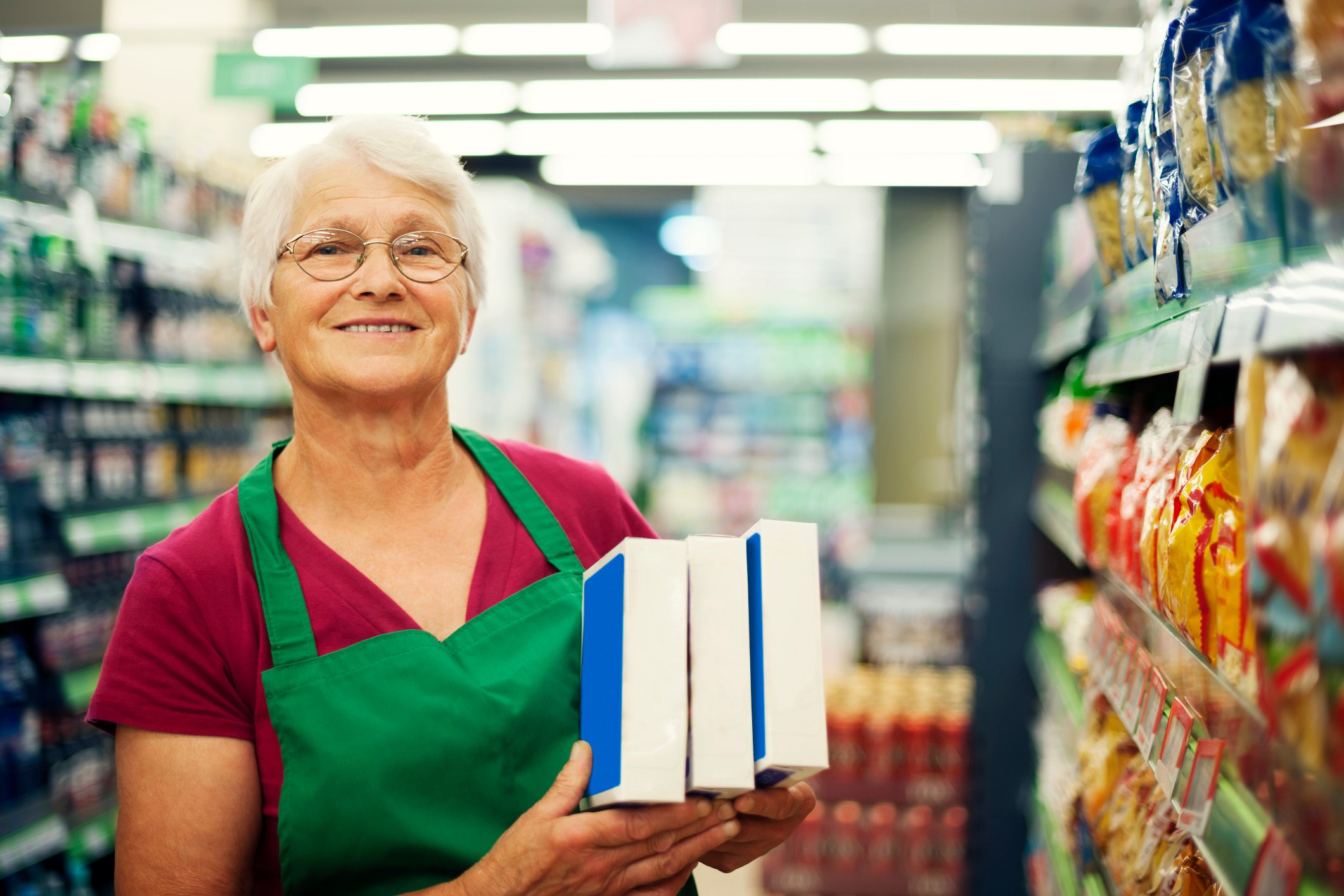 Older lady working stocking shelves.
