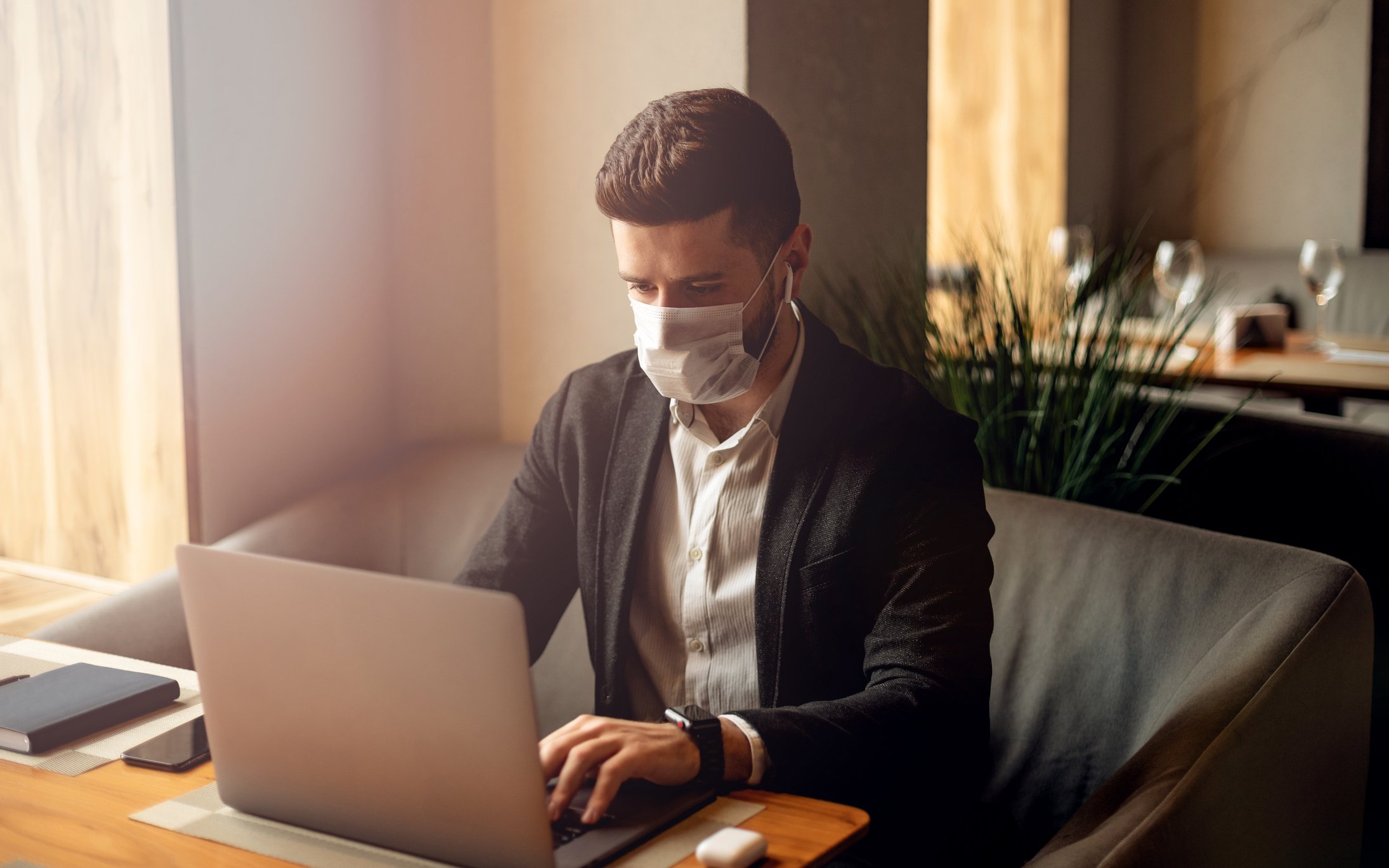 Man at laptop wearing mask