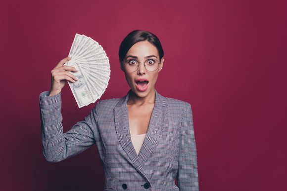A woman holding a fan of money.