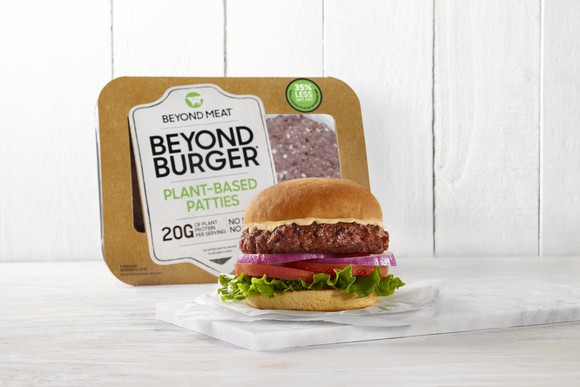 A product image shows a Beyond Meat burger sitting on a serving tray with a Beyond Meat package leaning up against the wall in the background.