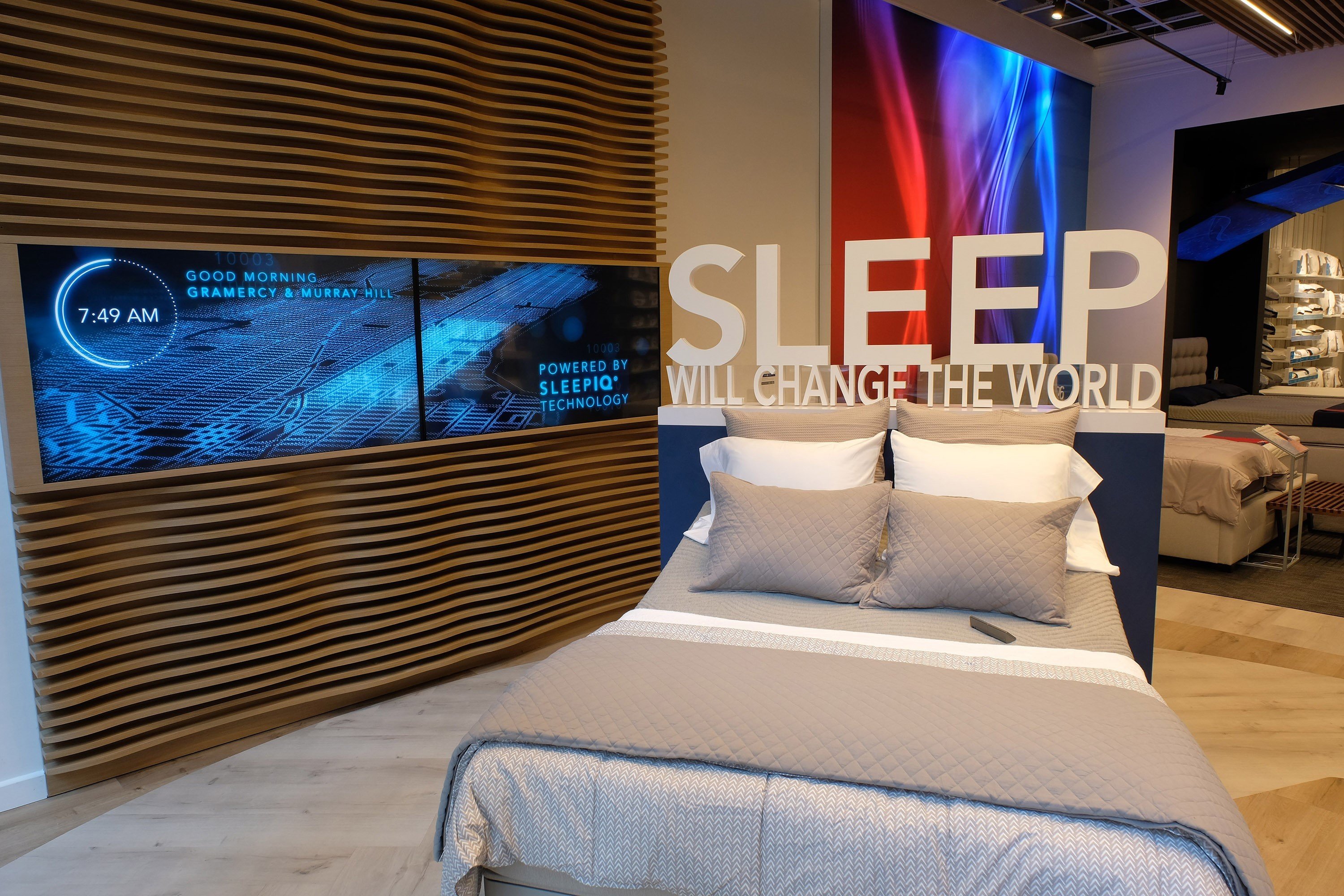 Sleep Number retail store display with bed and Sleep Will Change The World sign