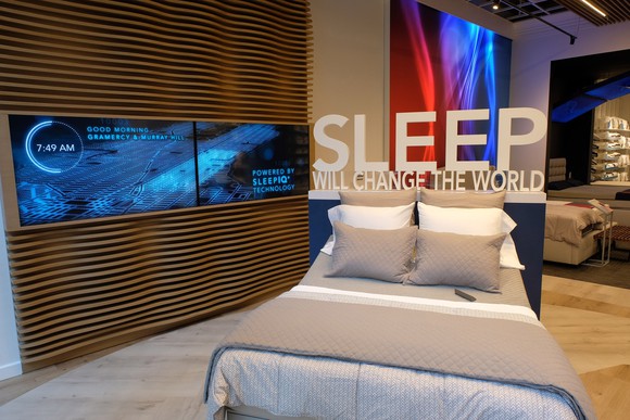 Sleep Number retail store display with bed and Sleep Will Change The World sign