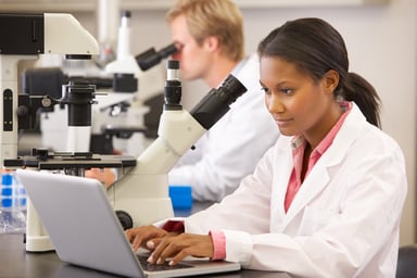 Scientists looking through microscopes