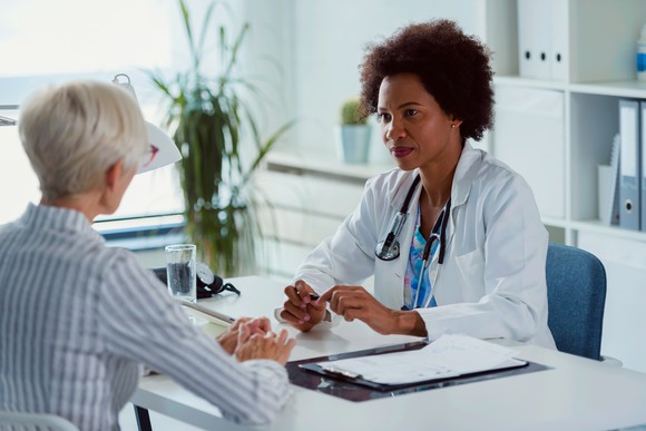 Senior woman sitting across the table from her physician.