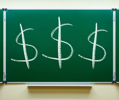 Three dollar signs on a chalkboard