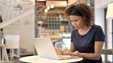 Distraught woman looking at laptop