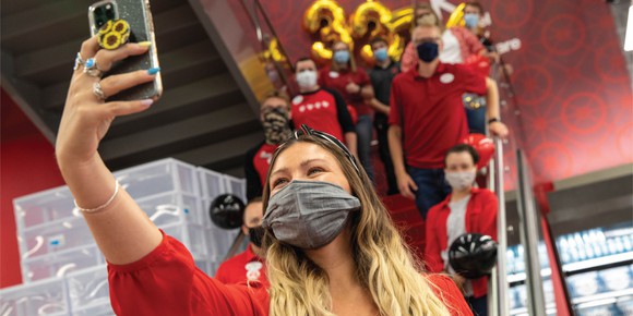 Target employee taking group photo with smartphone.