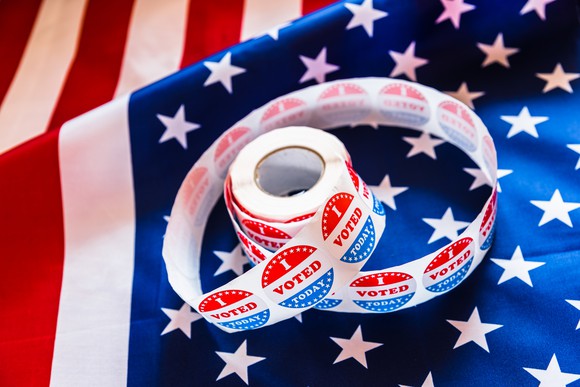 An American flag with a roll of "I Voted" stickers on it
